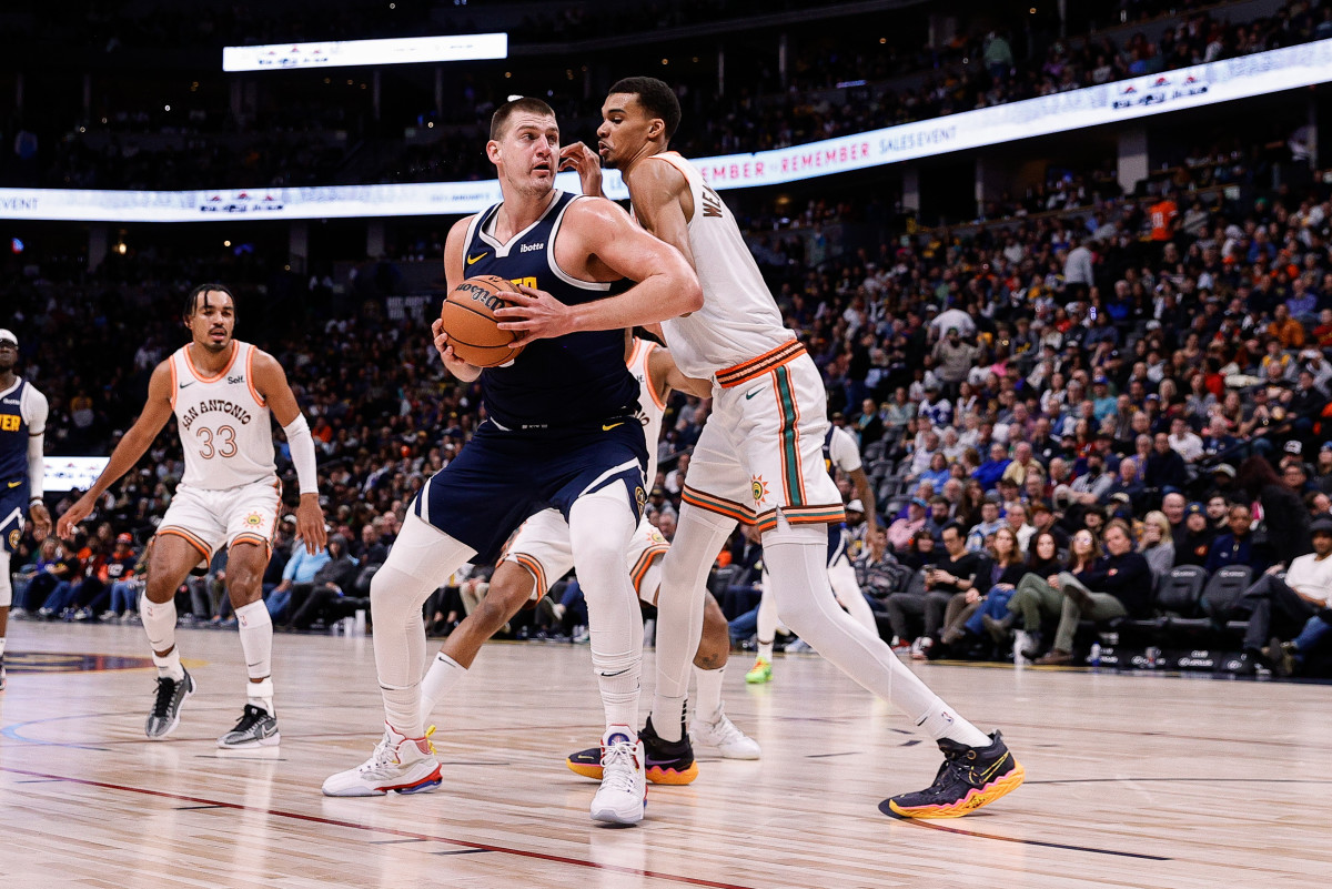 Denver Nuggets center Nikola Jokic (15) controls the ball as San Antonio Spurs center Victor Wembanyama (1) guards in the second quarter at Ball Arena.